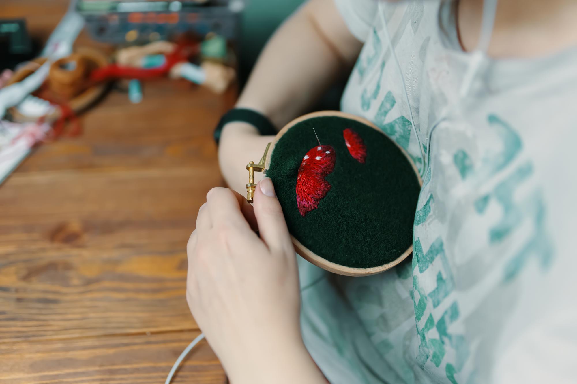 artisan preparing an embroidered badge on hoop